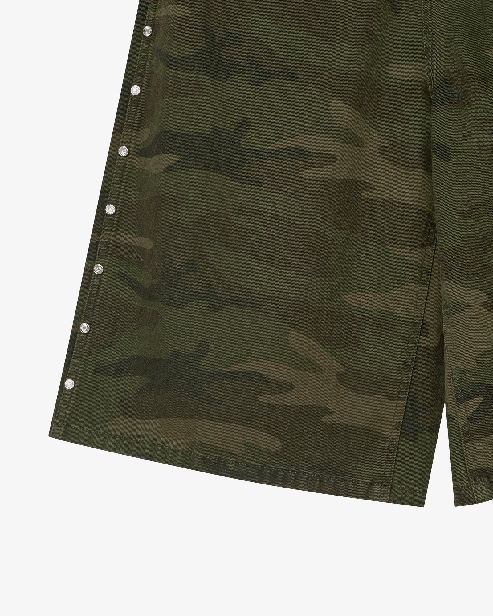 The hem of a pair of shorts in a camouflage print with silver studs on the side seams from Korean brand aeae, for sale at Shim House