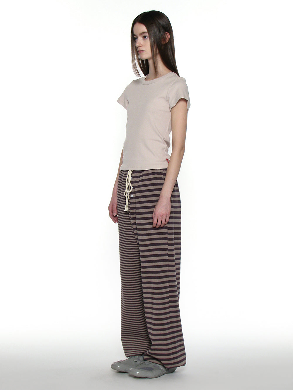 173cm tall woman facing side on wearing striped trackpants