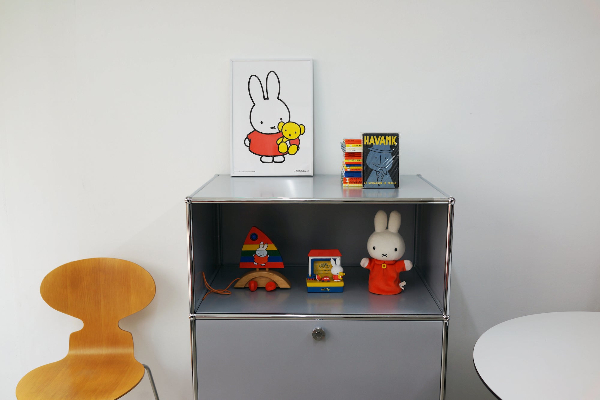 An A3 sized poster of Miffy in a red outfit holding her yellow teddy bear, sitting on top of a cabinet, printed by Korean brand Zero Per Zero, for sale at Shim House