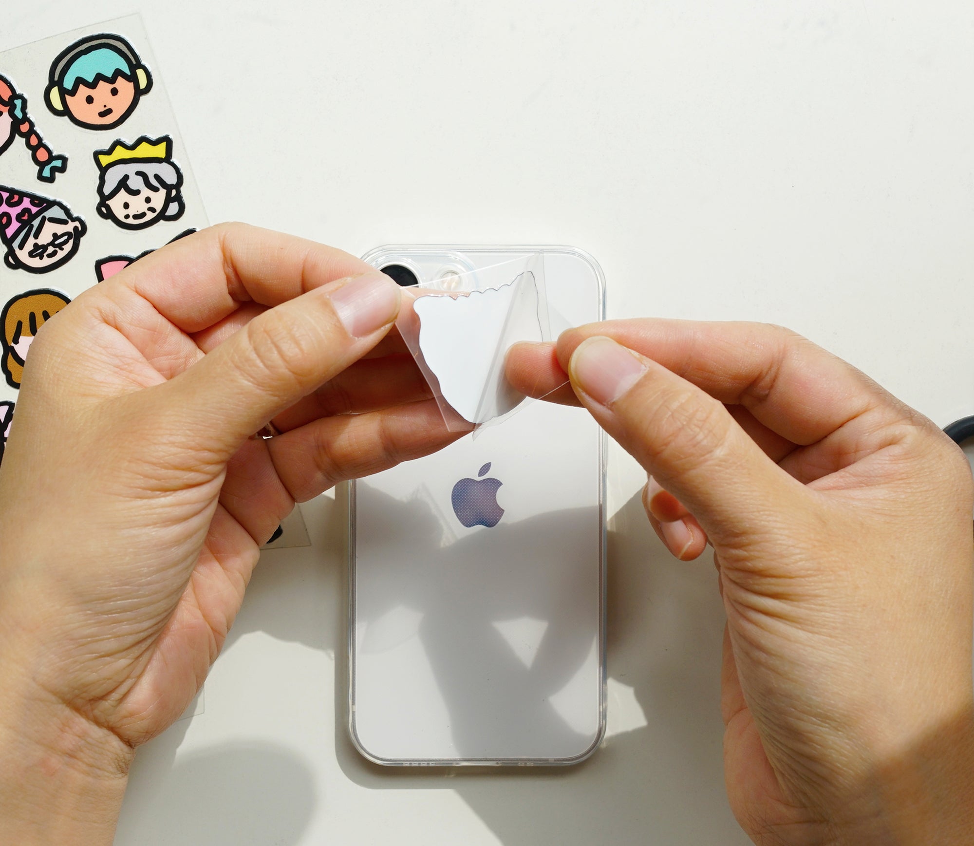 Two hands peeling the back off a sticker from Korean brand Zero Per Zero